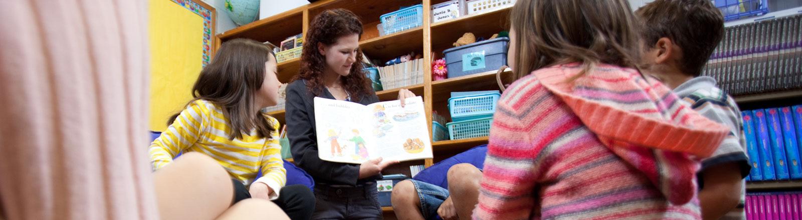 Student reading to younger children